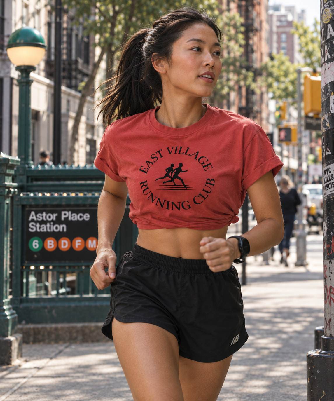 Woman running in East Village Running Club paprika tee
