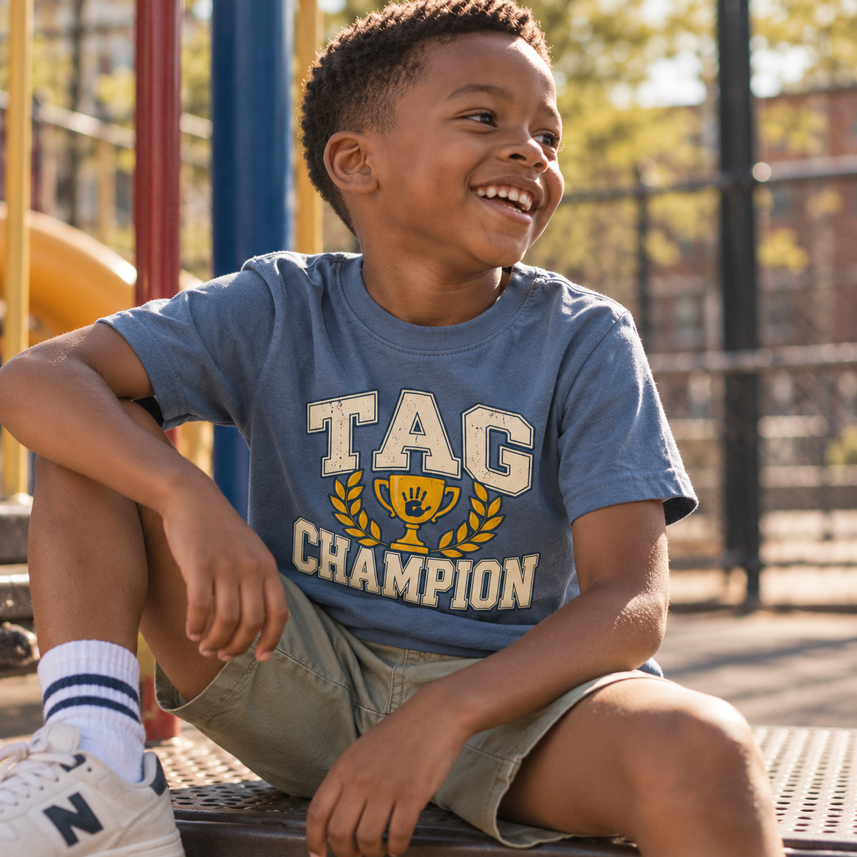 Child in Tag Champion tee sitting at the playground